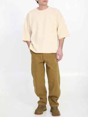男装米色棉质帆布裤子，绣有标志图案和多个口袋